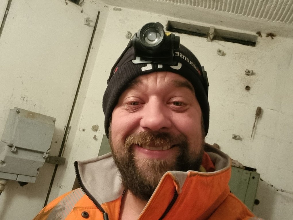 ein Mann macht ein Selfie in Arbeitskleidung, er hat eine Stirnlampe auf ein Mann macht ein Selfie in Arbeitskleidung, er hat eine Stirnlampe auf