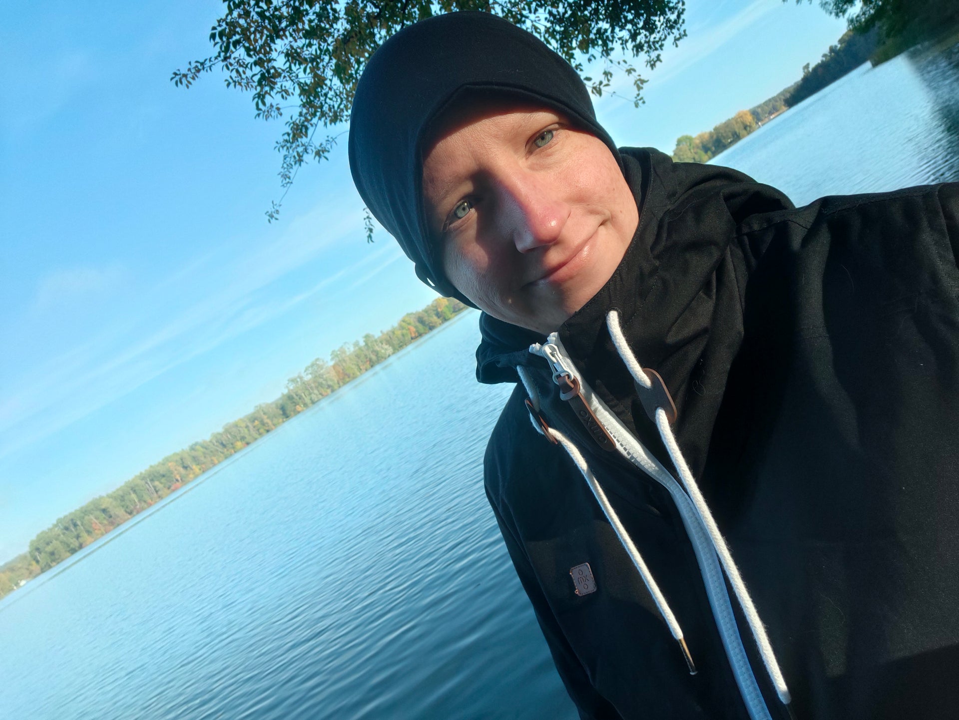 Eine Frau macht ein Selfie an einem Gewässer Eine Frau macht ein Selfie an einem Gewässer