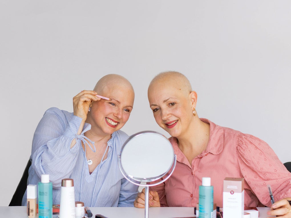 Zwei krebskranke Frauen beim look good feel better Seminar mit Kosmetik in der Hand Zwei krebskranke Frauen beim look good feel better Seminar mit Kosmetik in der Hand