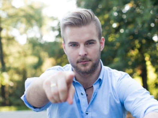 Ein Mann, der auf die Kamera zeigt Ein Mann, der auf die Kamera zeigt