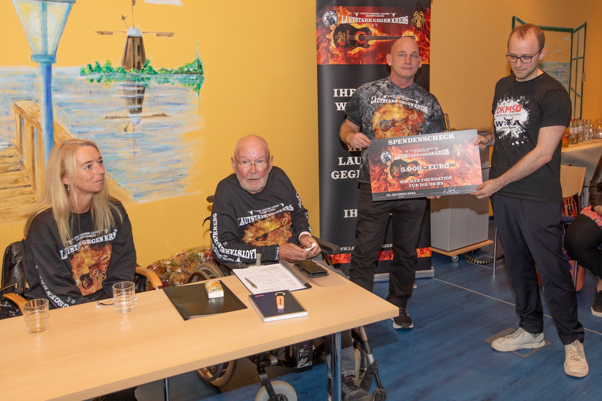 "Wackenopa" Günter Jacobs überreicht DKMS Volunteer Felix den symbolischen Scheck "Wackenopa" Günter Jacobs überreicht DKMS Volunteer Felix den symbolischen Scheck