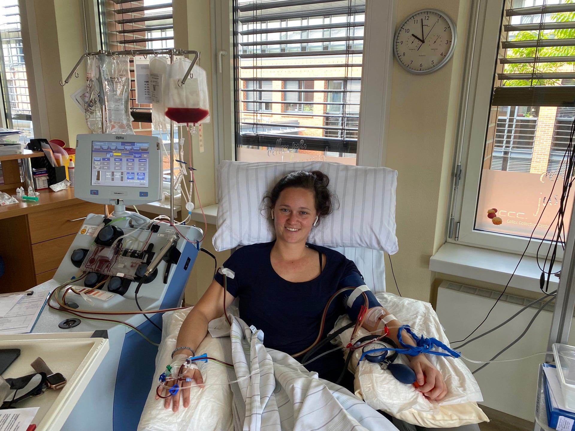 Eine Frau liegt während ihrer Stammzellspende in einem Bett, sie ist an ein Apherese-Gerät angeschlossen Eine Frau liegt während ihrer Stammzellspende in einem Bett, sie ist an ein Apherese-Gerät angeschlossen