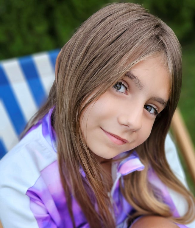 Ein Mädchen mit braunen Haaren lächelt. Ein Mädchen mit braunen Haaren lächelt.