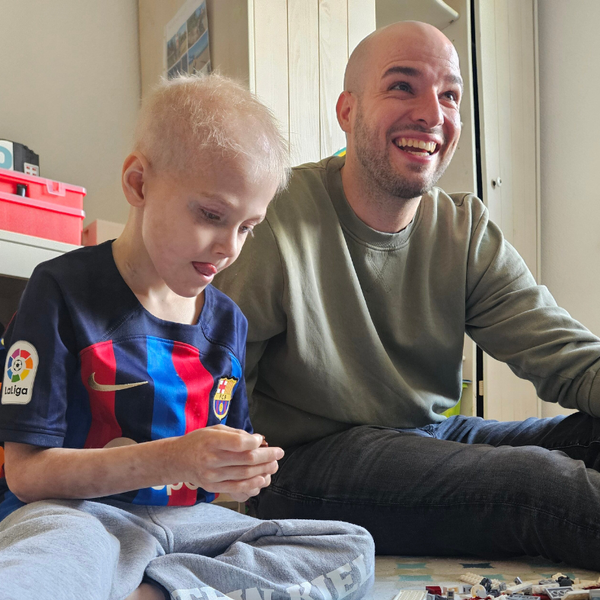 Ein Mann und ein Kind sitzen auf dem Boden Ein Mann und ein Kind sitzen auf dem Boden