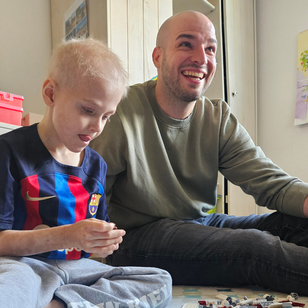 Ein Mann und ein Kind sitzen auf dem Boden Ein Mann und ein Kind sitzen auf dem Boden