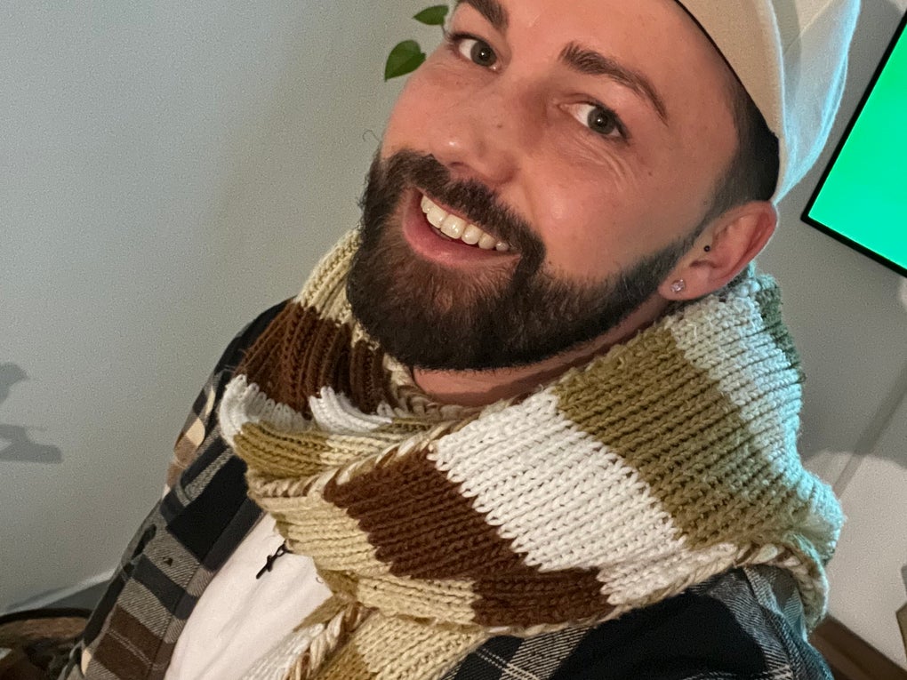 Ein Mann mit Hut lächelt in die Kamera. Ein Mann mit Hut lächelt in die Kamera.