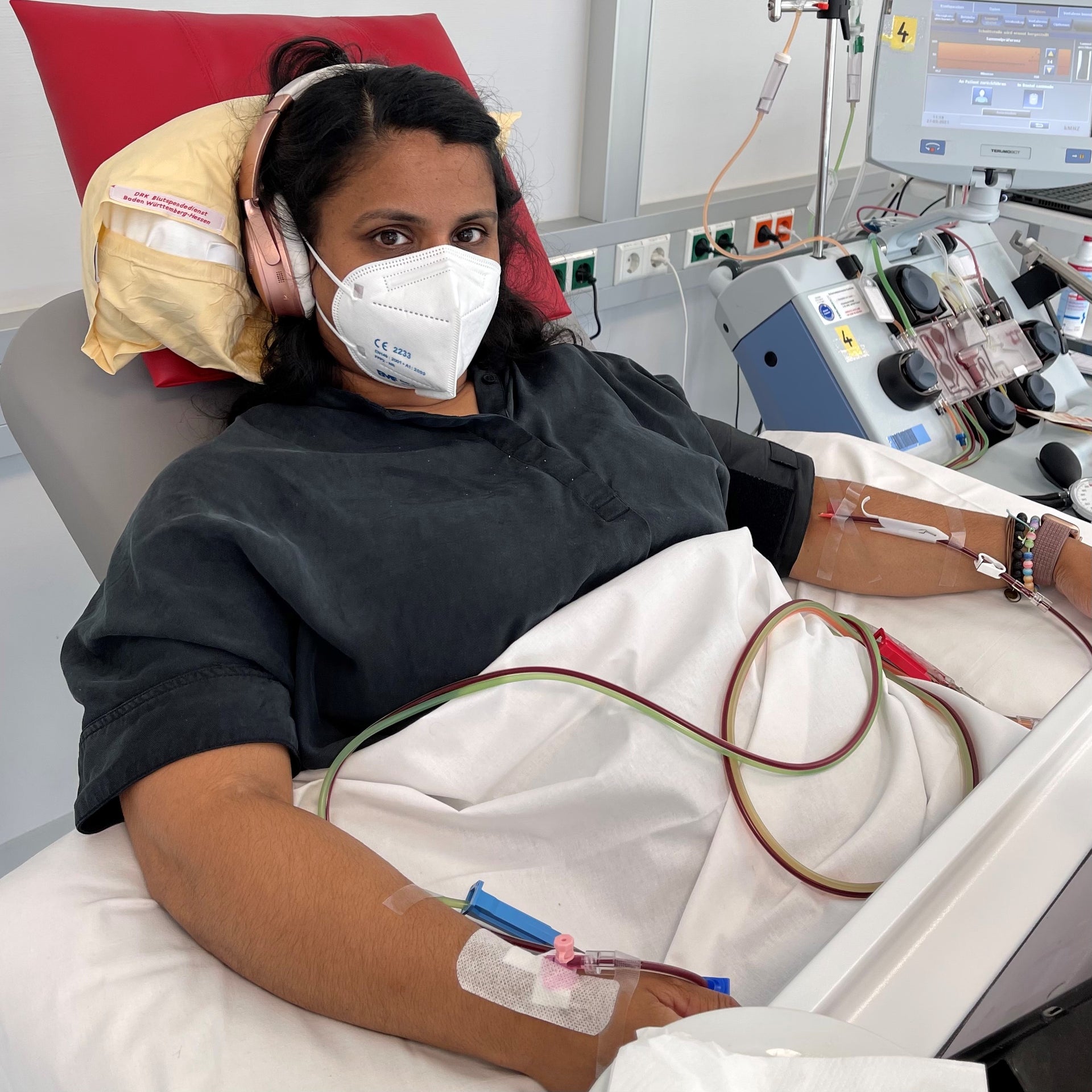 Denise bei ihrer Stammzellentnahme, sie liegt mit Maske und Kopfhörern in einem Bett Denise bei ihrer Stammzellentnahme, sie liegt mit Maske und Kopfhörern in einem Bett