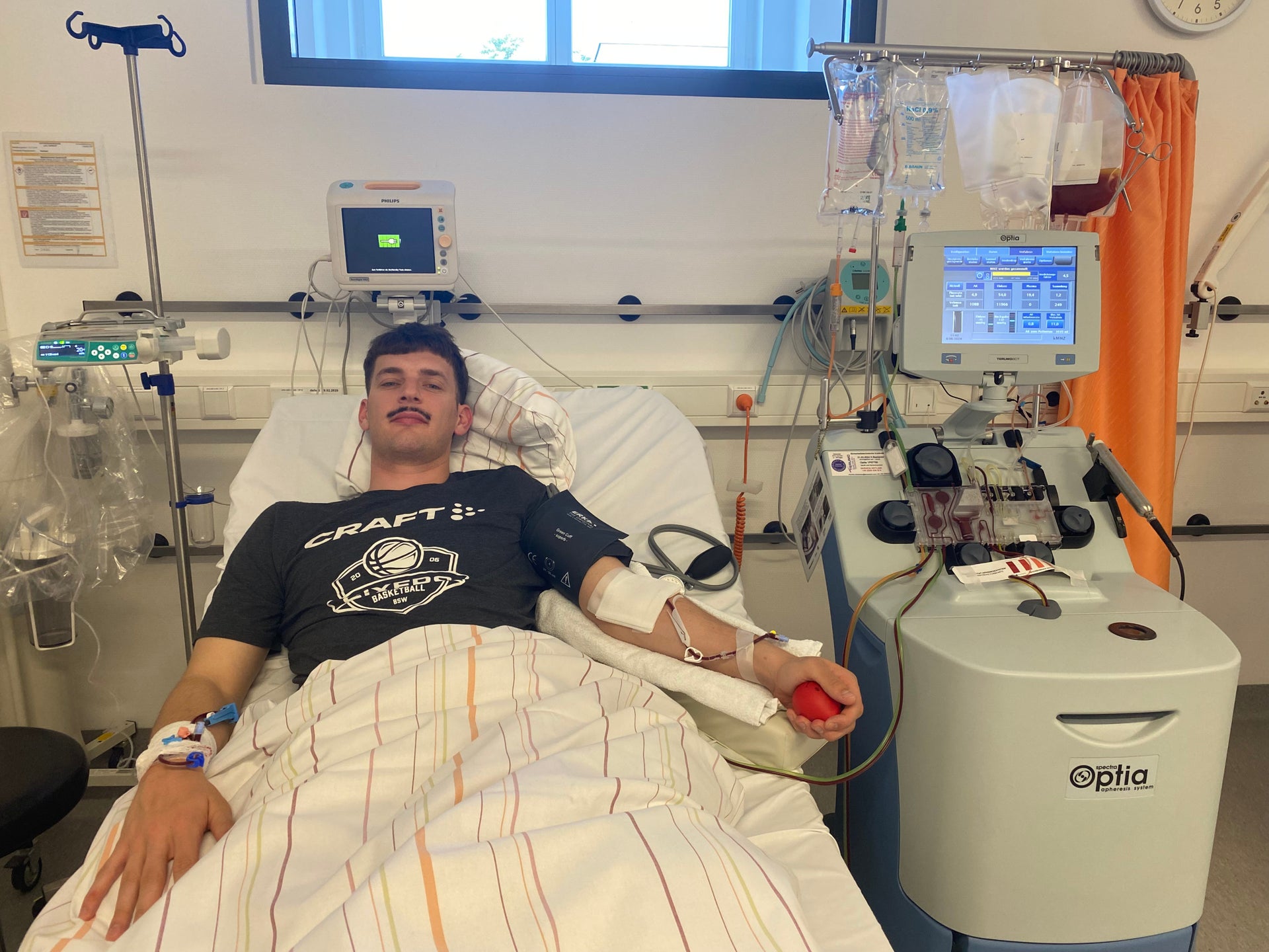 Ein Mann liegt in einem Krankenhausbett mit medizinischer Ausrüstung Ein Mann liegt in einem Krankenhausbett mit medizinischer Ausrüstung