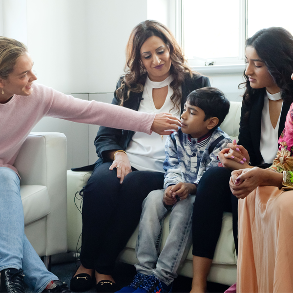 Eine Gruppe von Menschen sitzt auf einer Couch Eine Gruppe von Menschen sitzt auf einer Couch