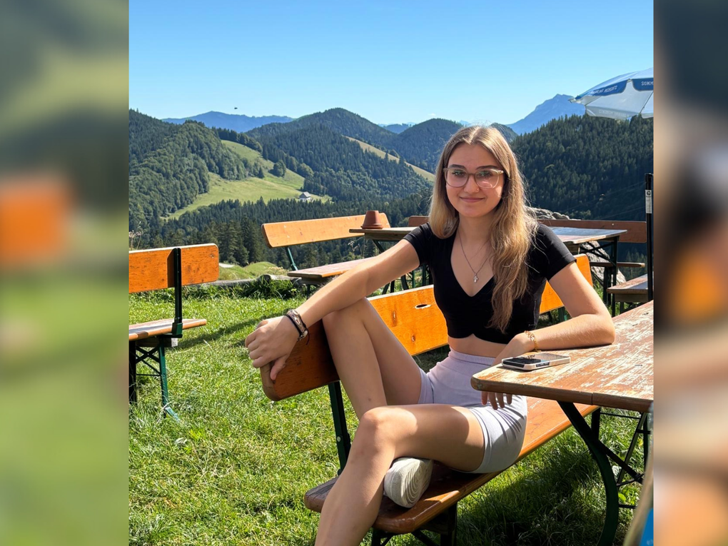 Eine junge Frau sitzt auf einer Bierbank in der Sonne. Eine junge Frau sitzt auf einer Bierbank in der Sonne.