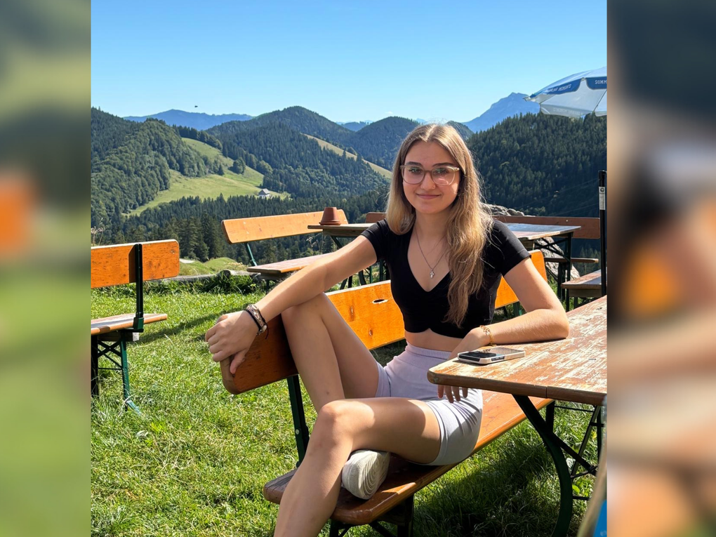 Eine junge Frau sitzt auf einer Bierbank in der Sonne. Eine junge Frau sitzt auf einer Bierbank in der Sonne.