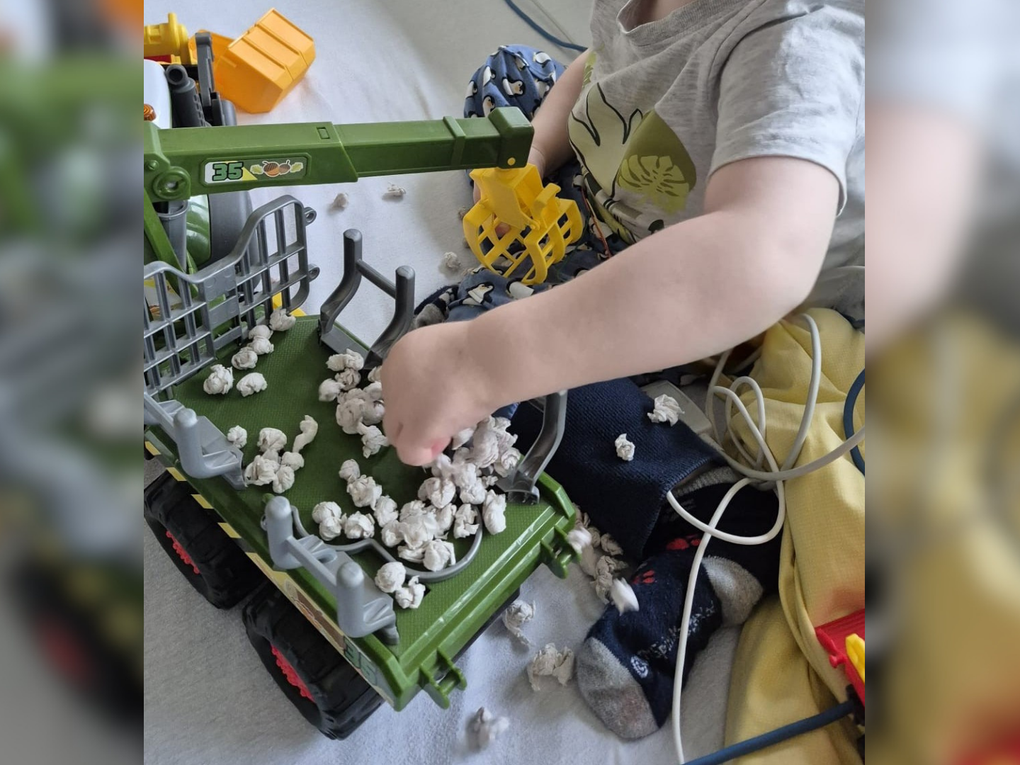 Ein Kind, das mit einem Spielzeugtraktor spielt Ein Kind, das mit einem Spielzeugtraktor spielt