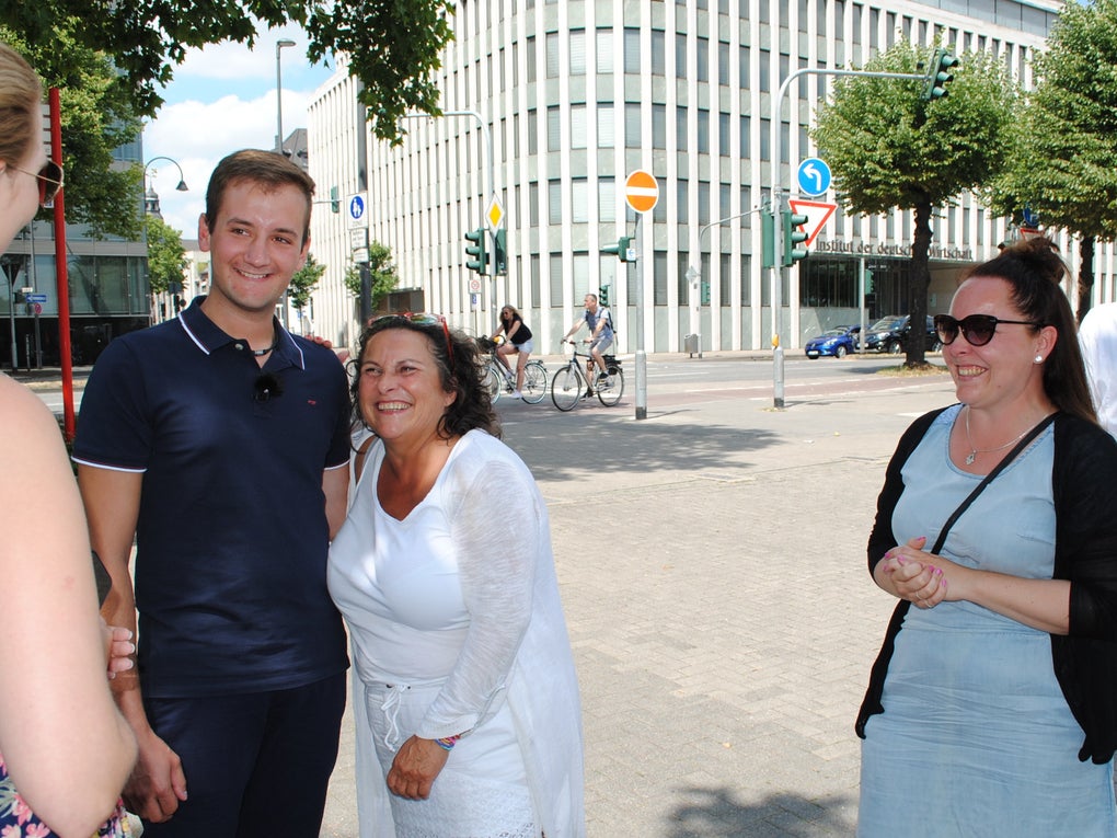 Eine Gruppe von Menschen, die in einer Stadt stehen Eine Gruppe von Menschen, die in einer Stadt stehen