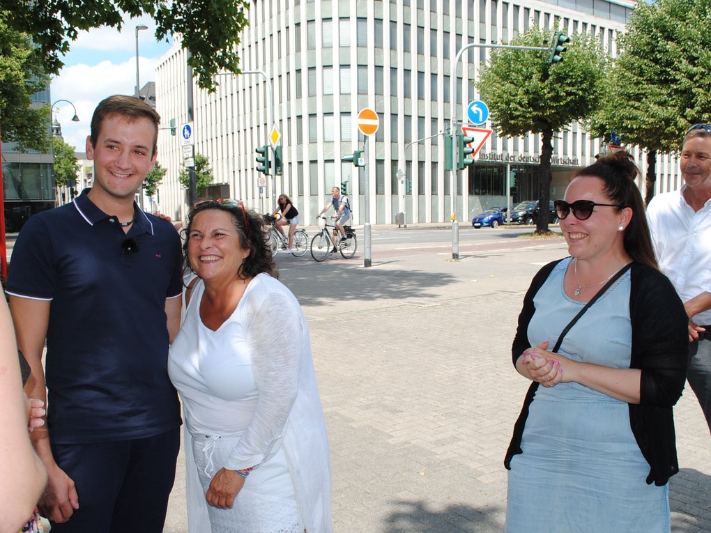 Eine Gruppe von Menschen, die in einer Stadt stehen Eine Gruppe von Menschen, die in einer Stadt stehen