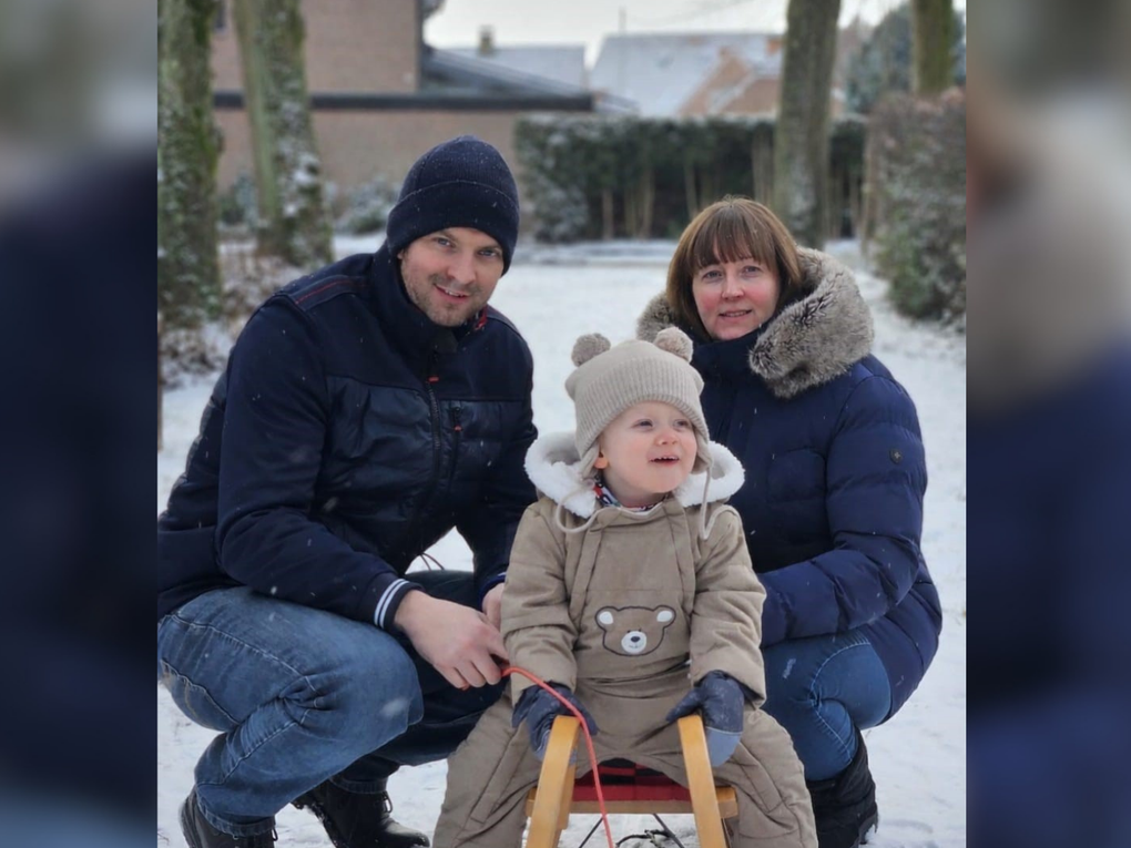 Ein Mann und eine Frau mit einem Kind auf einem Schlitten im Schnee Ein Mann und eine Frau mit einem Kind auf einem Schlitten im Schnee