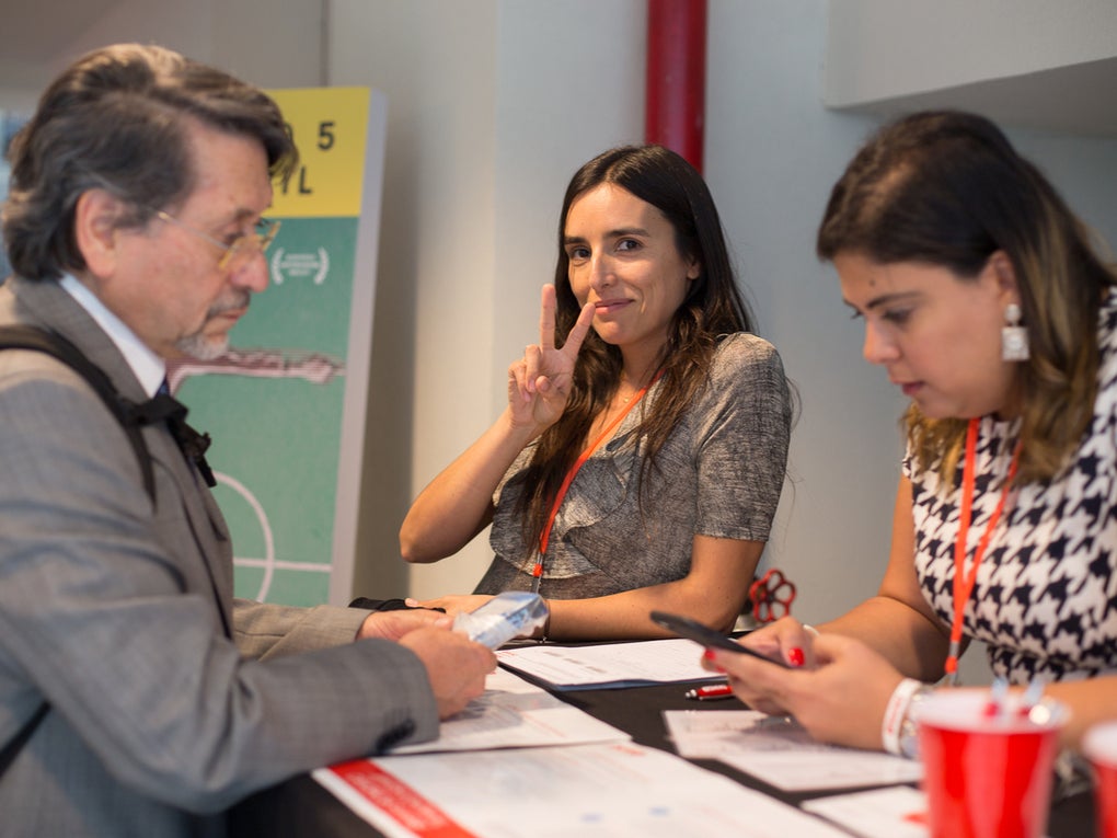 Eine Frau hält macht ein Peace Zeichen mit den Fingern, zwei andere Personen rahmen sie ein Eine Frau hält macht ein Peace Zeichen mit den Fingern, zwei andere Personen rahmen sie ein
