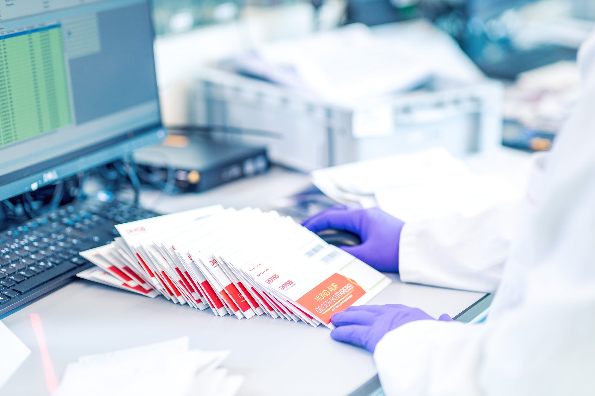 Eine Person mit Handschuhen begutachtet in einem Labor Spenderproben Eine Person mit Handschuhen begutachtet in einem Labor Spenderproben