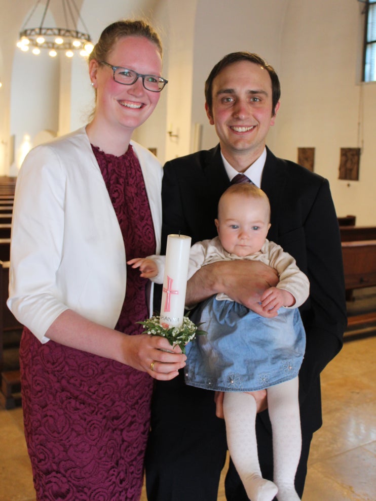 Der Patient Benedikt befindet sich mit seiner Frau Lisa und seiner Tochter Johanna in der Waldkapelle und lächeln in die Kamera.