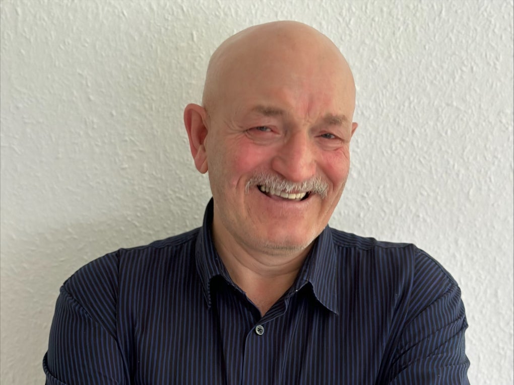 Mann mit Glatze und Schnäuzer lächelt in die Kamera Mann mit Glatze und Schnäuzer lächelt in die Kamera