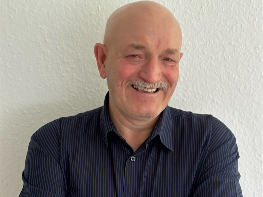 Mann mit Glatze und Schnäuzer lächelt in die Kamera Mann mit Glatze und Schnäuzer lächelt in die Kamera