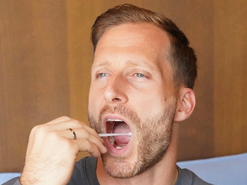 Ein Mann mit einem Wattestäbchen im Mund Ein Mann mit einem Wattestäbchen im Mund