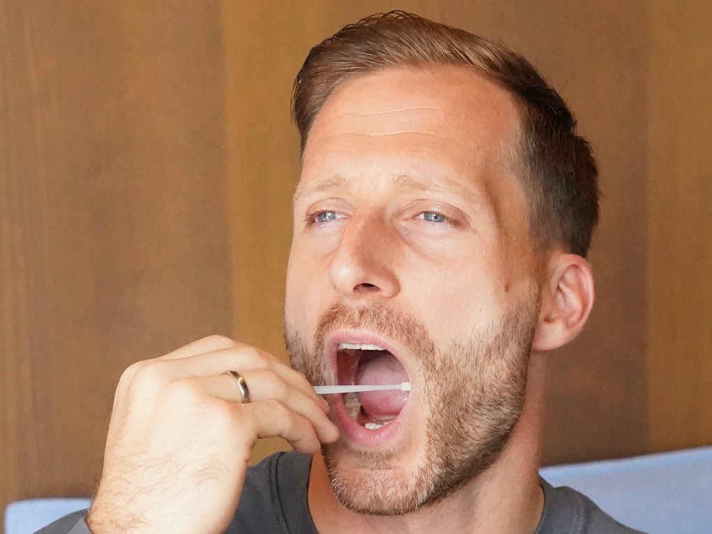 Ein Mann mit einem Wattestäbchen im Mund Ein Mann mit einem Wattestäbchen im Mund