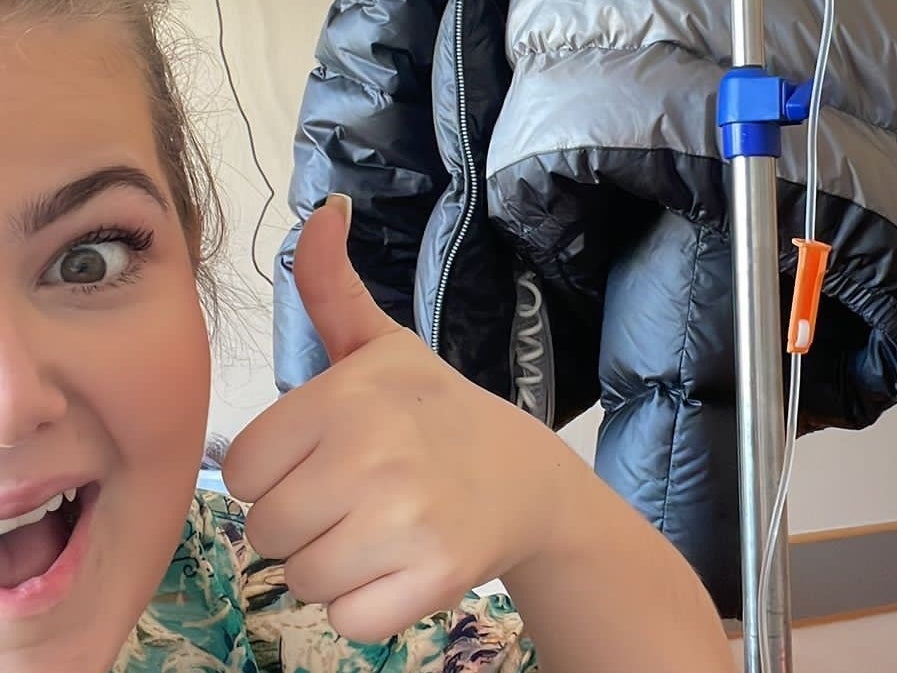 eine Frau lacht in die Kamera und macht ein Daumen hoch Symbol eine Frau lacht in die Kamera und macht ein Daumen hoch Symbol