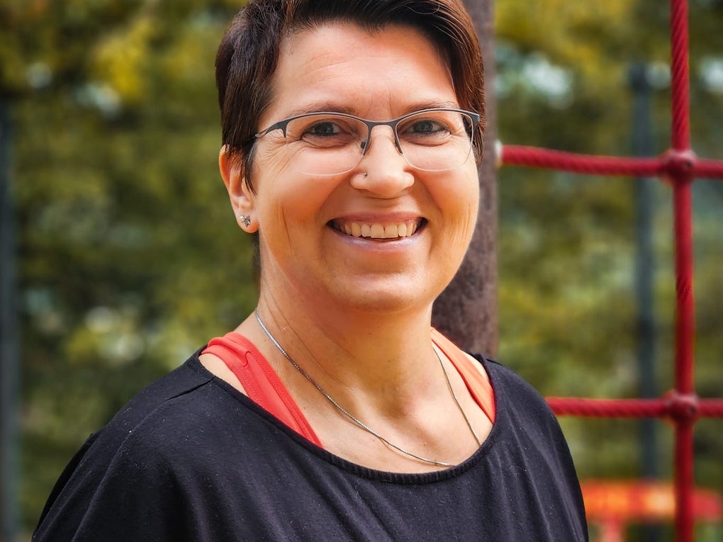 Frau mit kurzen braunen Haaren lächelt in die Kamera Frau mit kurzen braunen Haaren lächelt in die Kamera