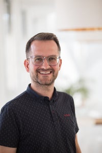 Ein Mann mit Brille lächelt Ein Mann mit Brille lächelt