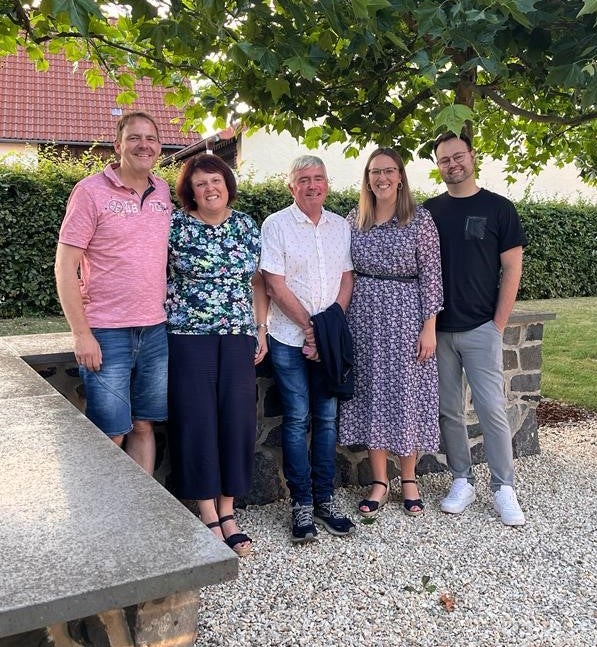 fünf Menschen posieren in einem Garten für ein Foto fünf Menschen posieren in einem Garten für ein Foto