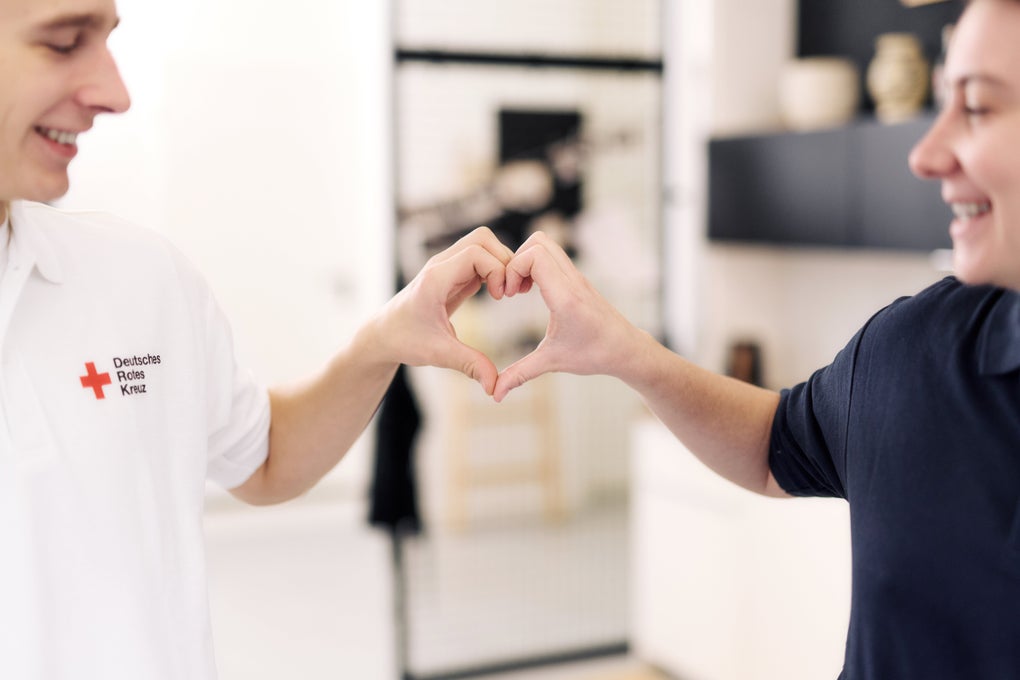 Zwei Mitarbeitende des DRK-Kreisverbands Börde halten ihre Hände zusammen, sodass sie ein Herz formen. Zwei Mitarbeitende des DRK-Kreisverbands Börde halten ihre Hände zusammen, sodass sie ein Herz formen.
