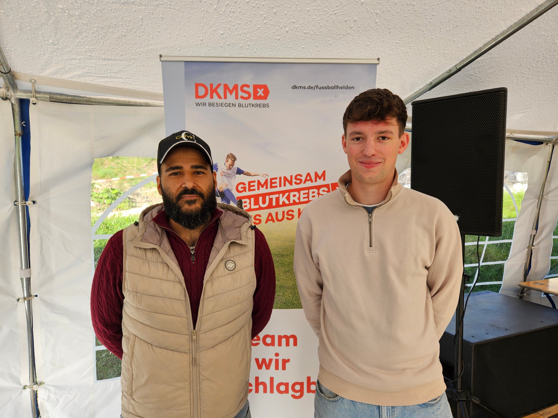 Zwei Männer stehen vor einem weißen Zelt Zwei Männer stehen vor einem weißen Zelt