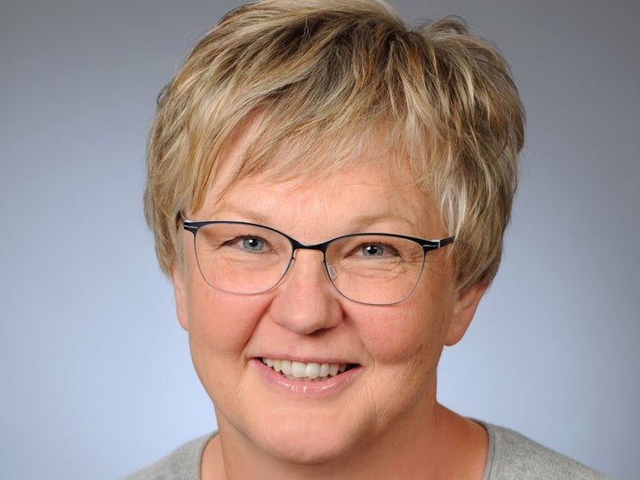 eine Frau mit Brille lächelt in die Kamera eine Frau mit Brille lächelt in die Kamera