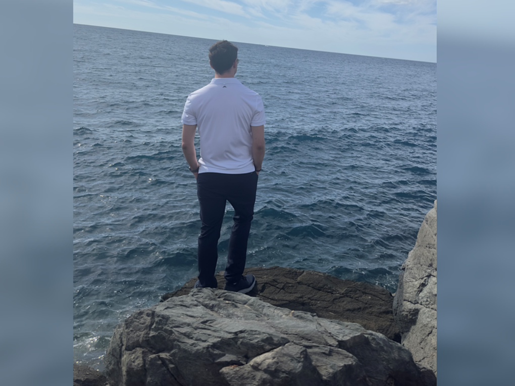 Ein Mann steht mit dem Rücken zur Kamera auf einem Felsen und schaut aufs Meer. Ein Mann steht mit dem Rücken zur Kamera auf einem Felsen und schaut aufs Meer.
