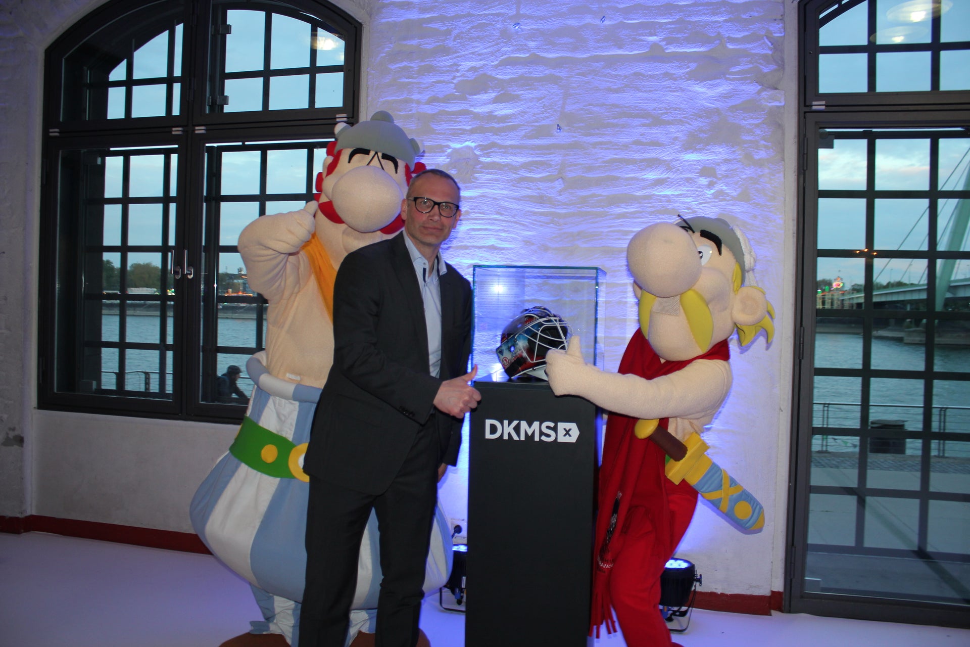 Ex-Nationalspieler Mirko Lüdemann mit den WM Maskottchen vor dem DKMS Helm Ex-Nationalspieler Mirko Lüdemann mit den WM Maskottchen vor dem DKMS Helm