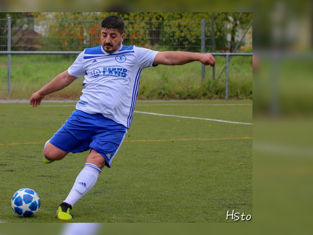 Ein Mann, der einen Fußball schießt Ein Mann, der einen Fußball schießt