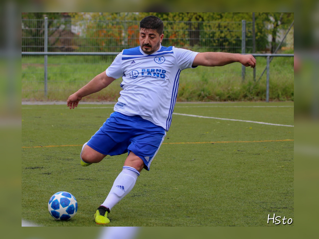 Ein Mann, der einen Fußball schießt Ein Mann, der einen Fußball schießt