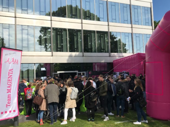 Eine Gruppe von Menschen, die vor einem Gebäude stehen Eine Gruppe von Menschen, die vor einem Gebäude stehen