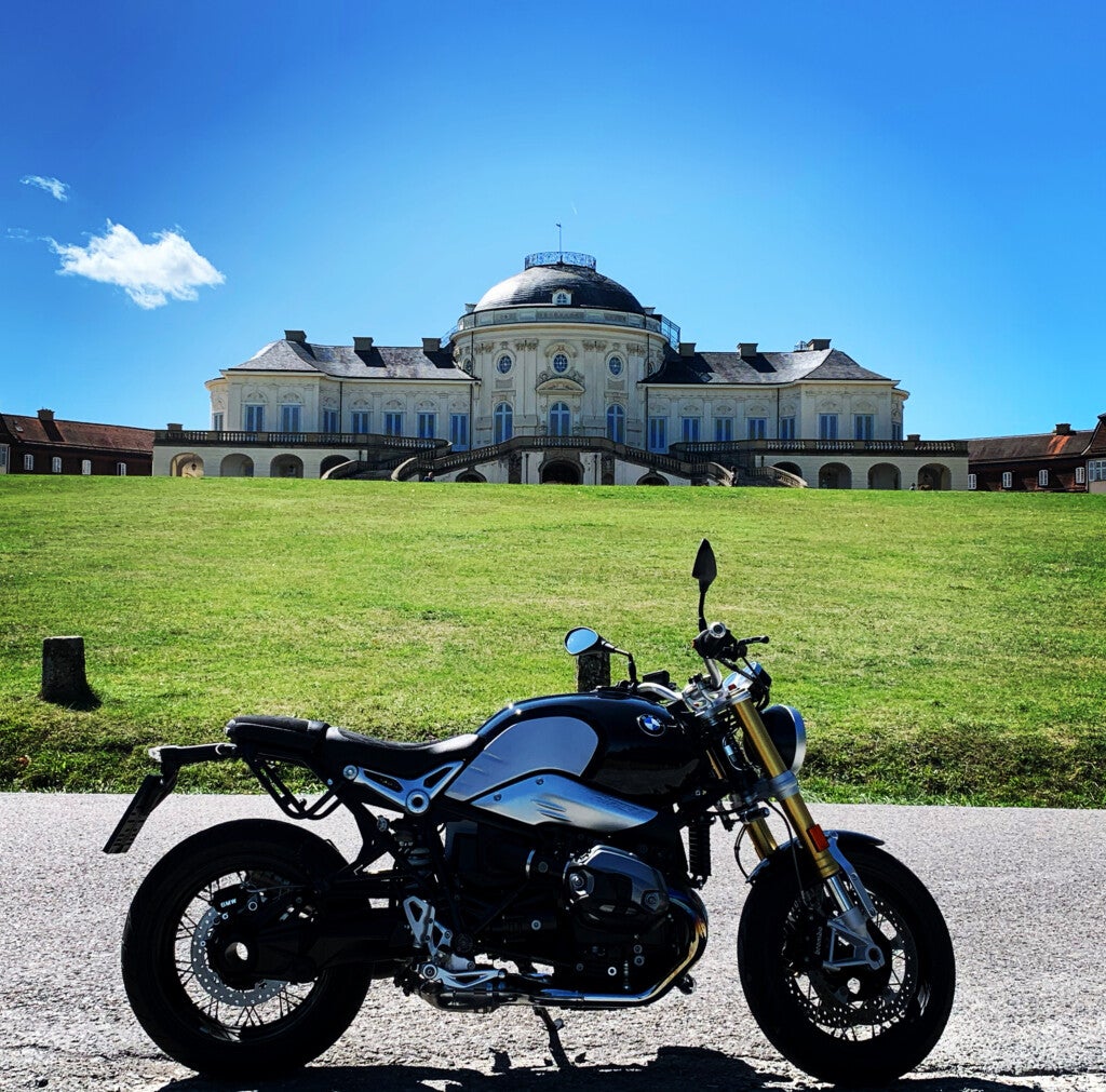 Ein vor einem großen Gebäude geparktes Motorrad Ein vor einem großen Gebäude geparktes Motorrad