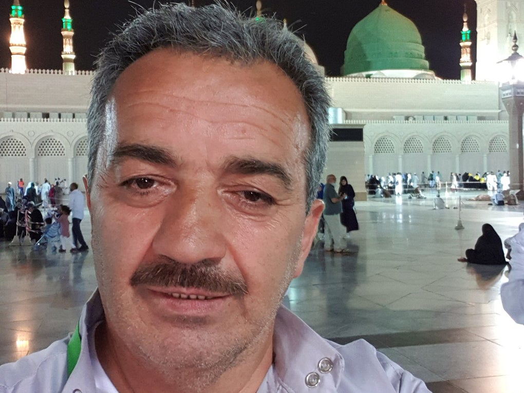 Ein Mann macht ein Selfie auf einem hell erleuchteten Platz vor der Prophetenmoschee in Medina. Im Hintergrund sind die grüne Kuppel und mehrere beleuchtete Minarette zu sehen. Der Mann trägt ein helles Hemd mit einem grünen Umhängeband und blickt direkt in die Kamera. Ein Mann macht ein Selfie auf einem hell erleuchteten Platz vor der Prophetenmoschee in Medina. Im Hintergrund sind die grüne Kuppel und mehrere beleuchtete Minarette zu sehen. Der Mann trägt ein helles Hemd mit einem grünen Umhängeband und blickt direkt in die Kamera.
