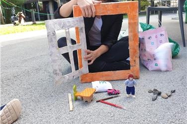 Clara Peretti, QAES-Referentin, zeigt den Kids-Camp-Kindern spielerisch, wie man die Fenster richtig öffnet, um die schlechte Luft mit der guten Luft auszutauschen (Foto: Umweltagentur).