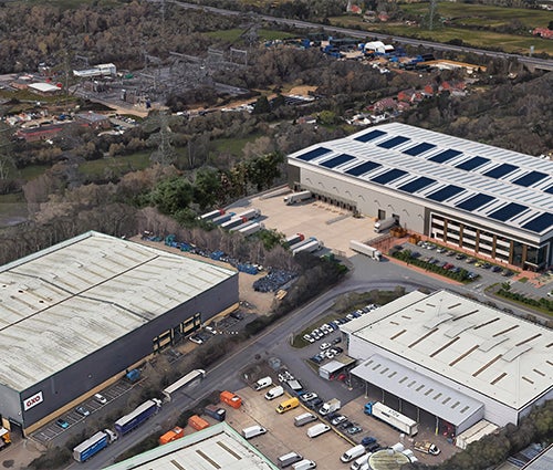 Industrial units aerial view showing lorrys and buildings surrounded by green space