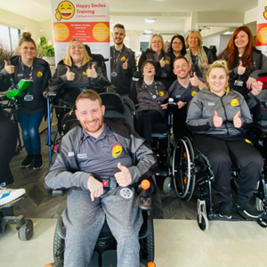 Members of the Happy Smiles team pose for the camera, with their thumbs up.