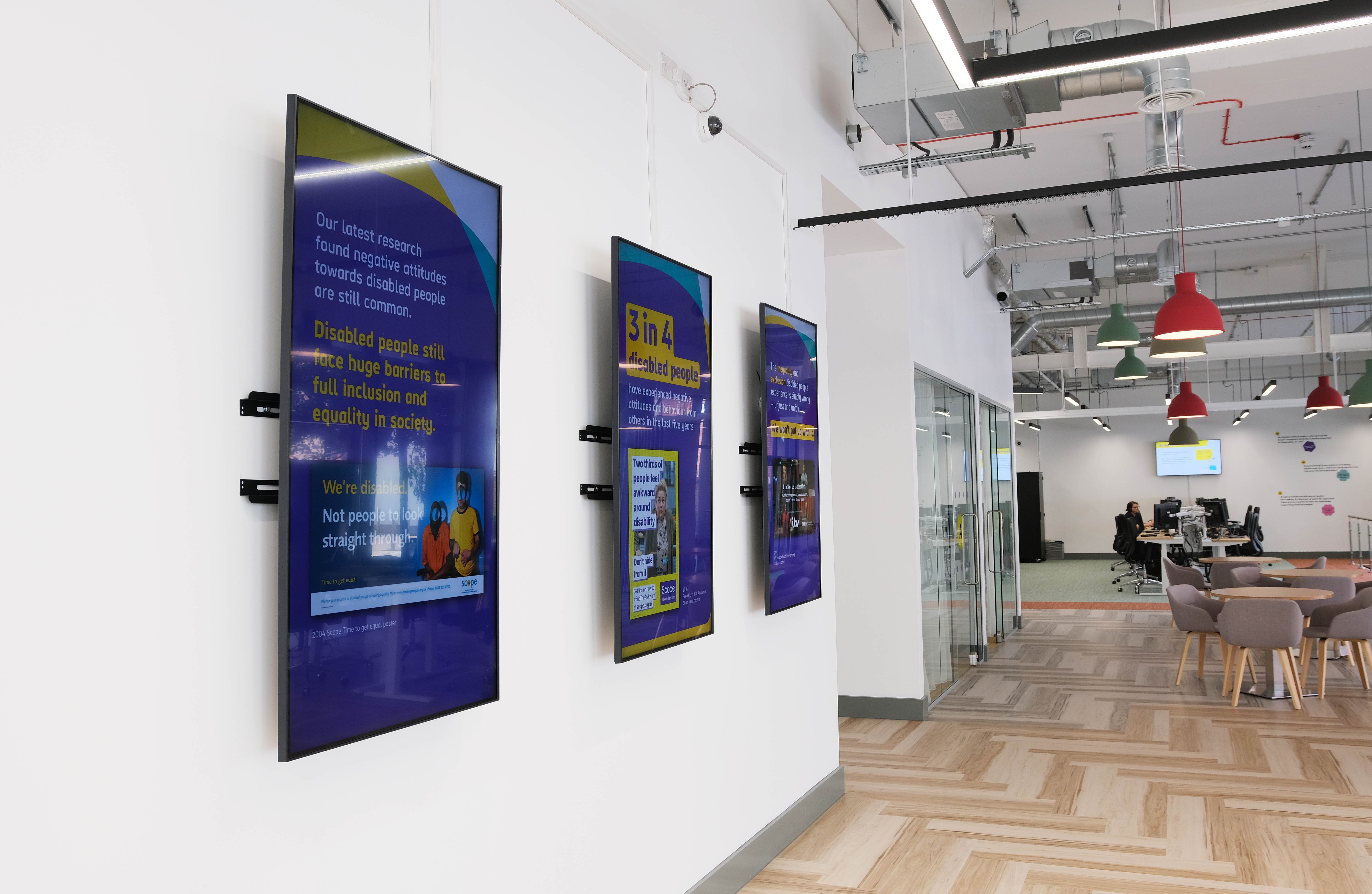 The 3 digital screens in front of the main entrance, displaying essential information about Scope's history and the Leeds hub.