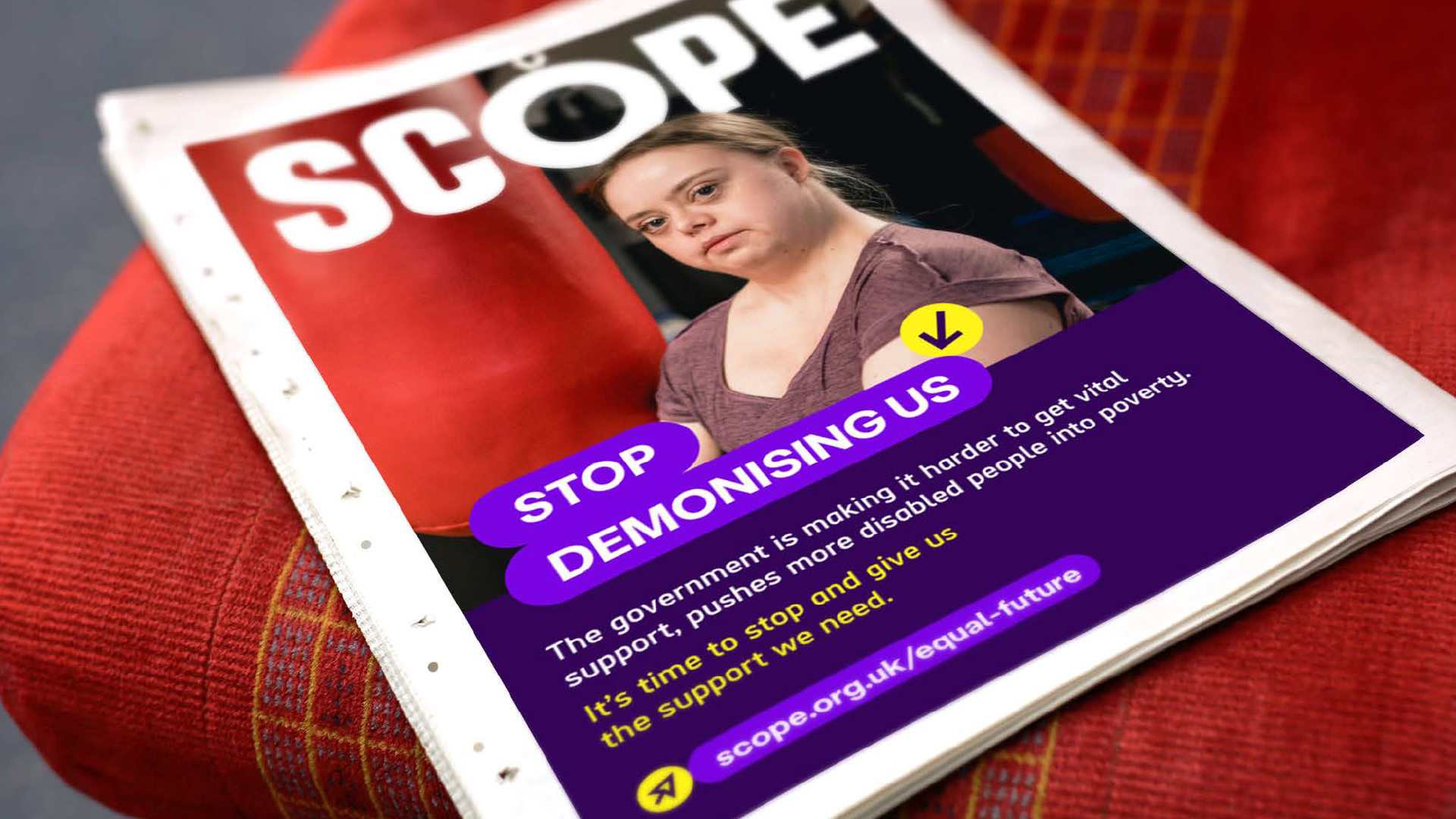 Newspaper ad with Scope logo overlaid a photo. Lozenge used at the bottom of photo 'stop demonising us' dark purple block at the bottom with summary and link to Scope strategy in lozenge. 