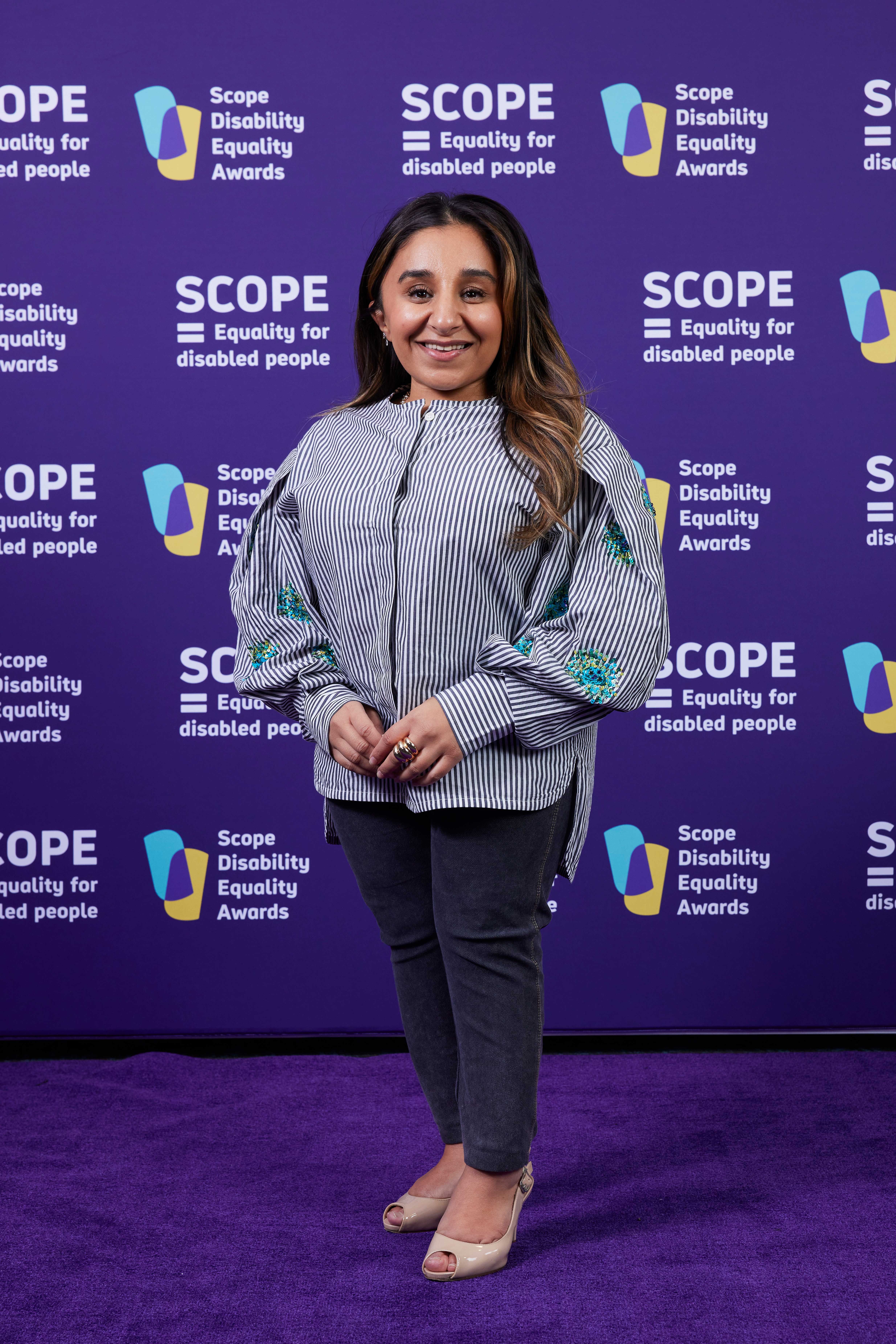 A woman standing in front of a purple wall