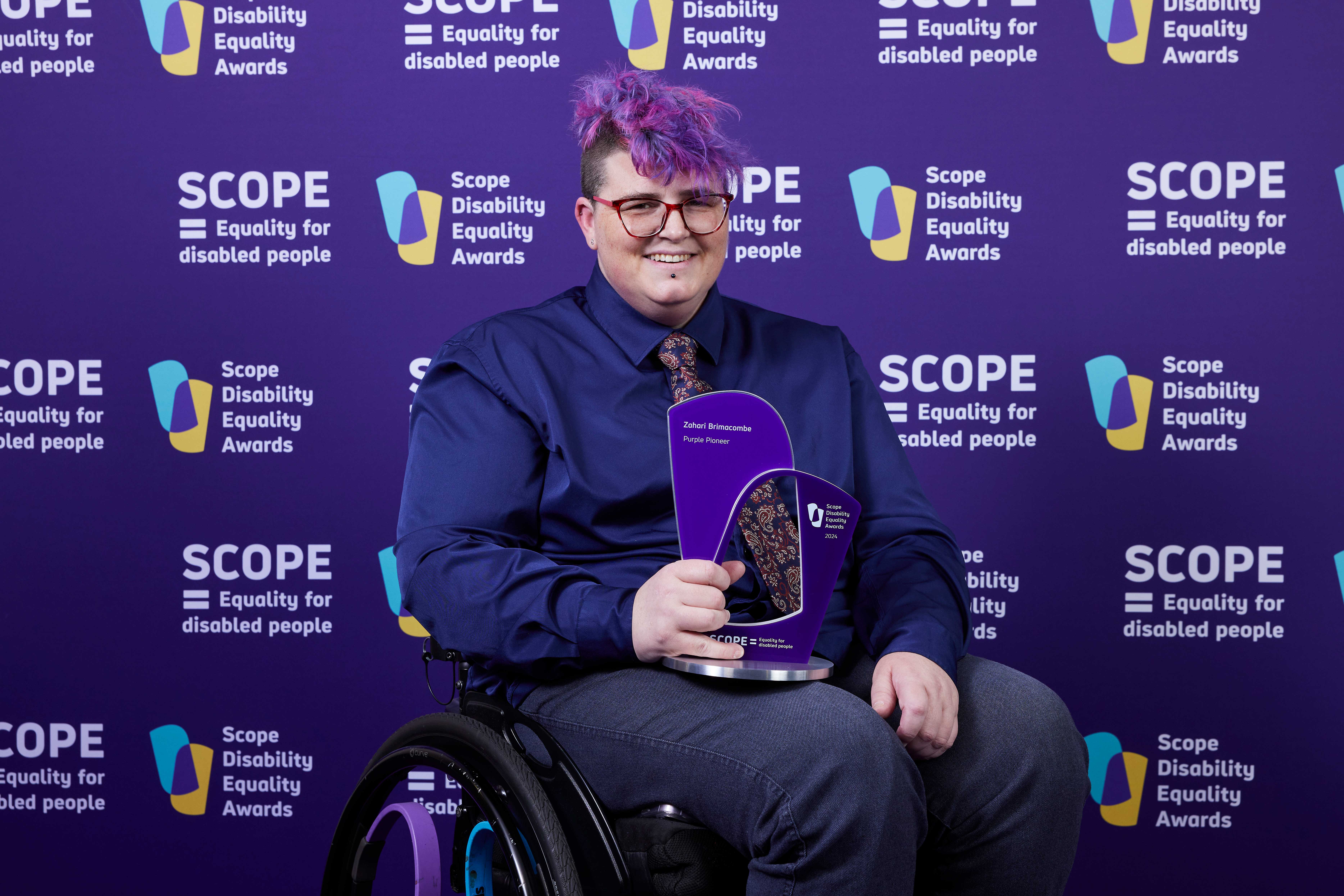 A person in a wheelchair holding a trophy