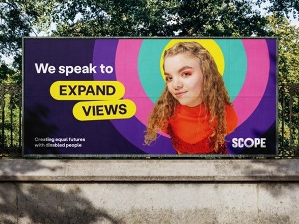 Billboard with photo overlaid multi-coloured amplification circle. To the left, text says 'we speak to' then in 2 lozenges 'expand views'. Our logo in bottom right and tagline on bottom left.