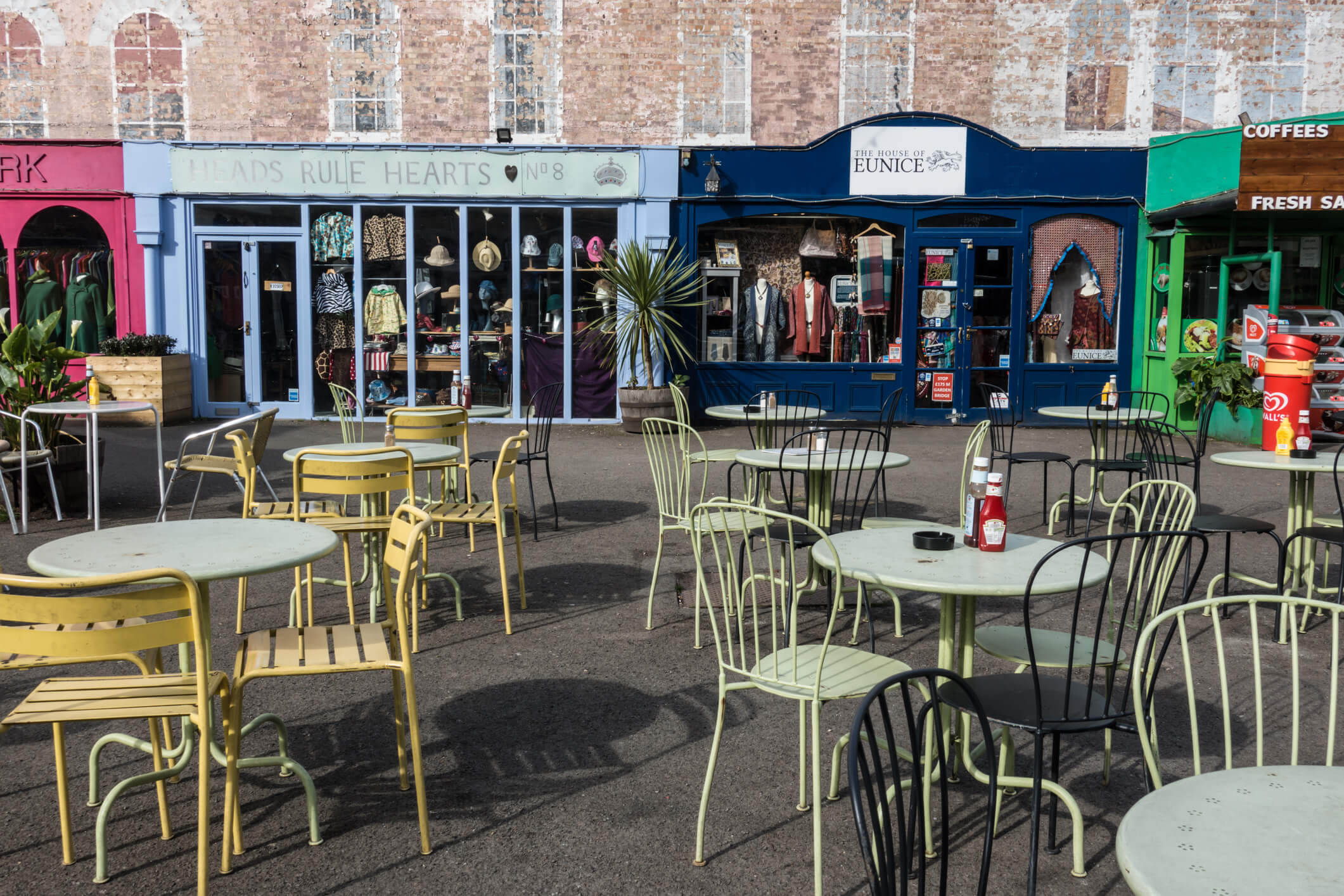 row of shops in Southbank, London with coloured tables outside