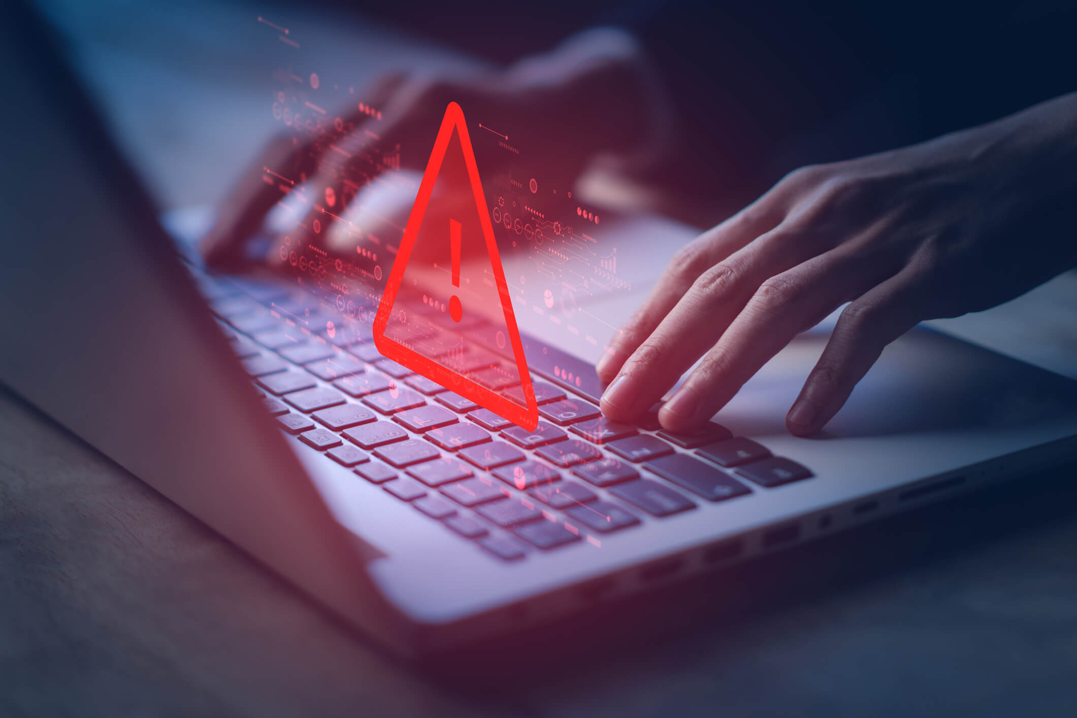 male typing on mac laptop with a red warning triangle animation